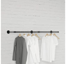 Nástenný vešiak s oblečením visiacim pred tehlovou stenou