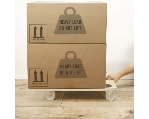 Dve sťahovacie krabice s upozornením ťažký náklad nezdvíhať, naskladané na valčekovej doske