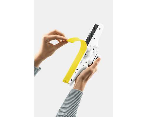 Osoba vymieňa gumovú lištu okenného vysávača.