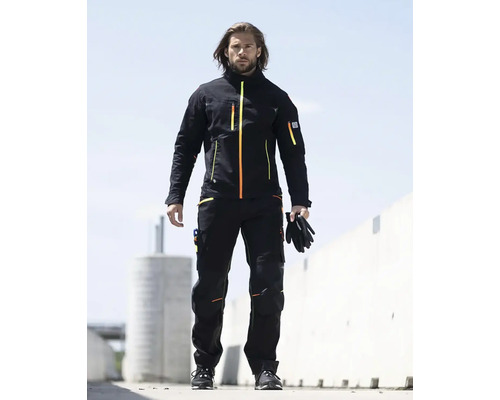 Muž má na sebe pracovný odev pozostávajúci z bundy a nohavíc