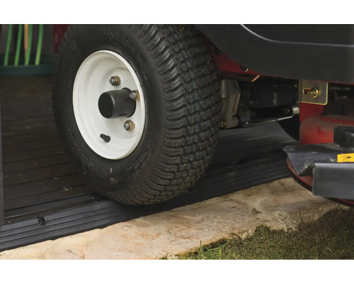 Detailný záber na koleso záhradného traktora na čiernej rampe