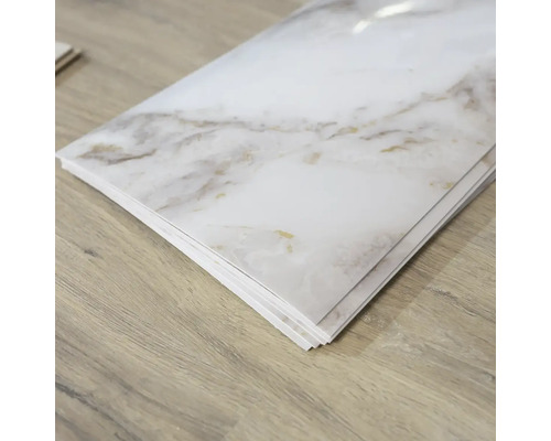 Viaceré biele vinylové podlahové dlaždice so vzhľadom mramoru na drevenej podlahe
