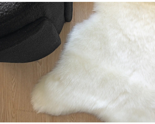 Biely koberec z umelej kožušiny vedľa kresla