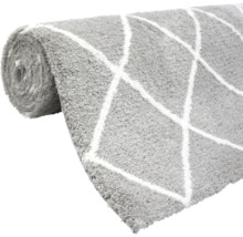 Zrolovaný sivý koberec s geometrickým vzorom