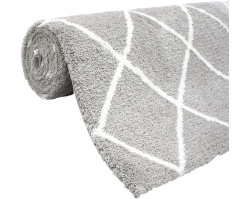 Sivý koberec s kosoštvorcovým vzorom zrolovaný