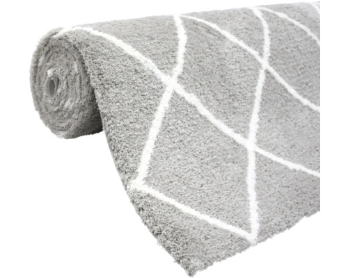 Zrolovaný sivý koberec s bielym kosoštvorcovým vzorom