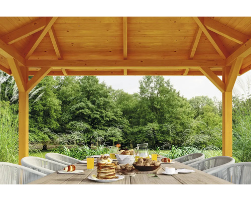 Drevený altánok s prestretým stolom v záhrade