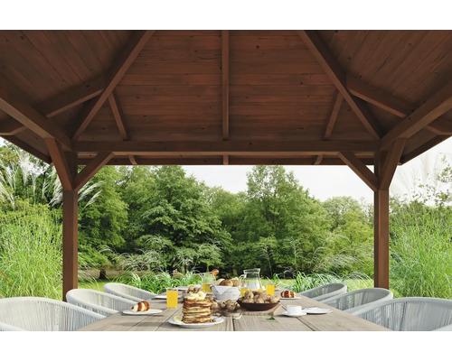 Záhradný altánok s prestretým stolom a výhľadom do záhrady