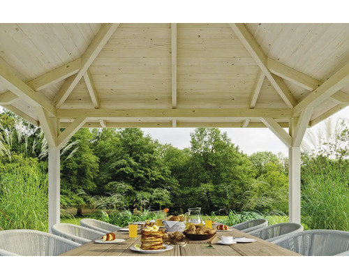 Drevený záhradný altánok s prestretým stolom a stoličkami v záhrade