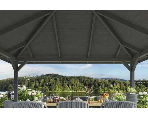 Drevený záhradný altánok s prestretým stolom v záhrade pri jazere