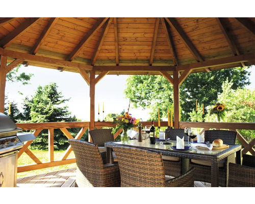 Drevený záhradný altánok so záhradným nábytkom a grilom pre chvíle oddychu vonku.