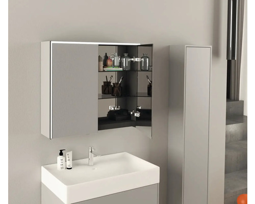 Moderná kúpeľňa s umývadlom, zrkadlovou skrinkou a vysokou skriňou pre svetlé a usporiadané prostredie.