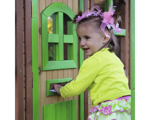 Mladé dievča vkladá list do poštovej schránky hracieho domčeka