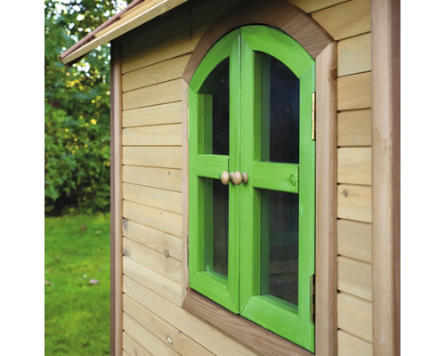 Detailný pohľad na drevený domček na hranie so zeleným oknom a okenicami