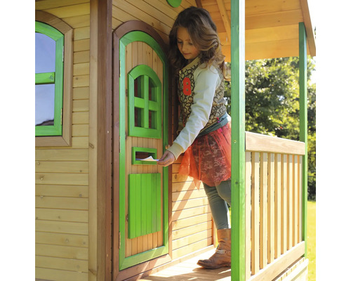 Dieťa vkladá list do poštovej schránky dreveného domčeka na hranie