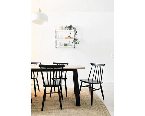 Jedáleň s dreveným stolom, čiernymi stoličkami a nástennou policou