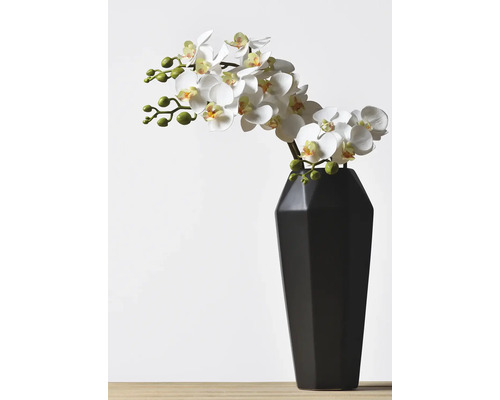 Umelá orchidea vo váze ako dekorácia.