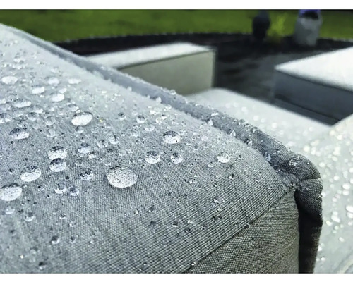 Detailný záber vodoodpudivého vankúša záhradného nábytku s kvapkami vody.