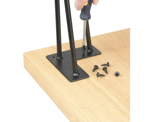 Montáž čiernych stolových nôh pomocou skrutiek na stolovú dosku.