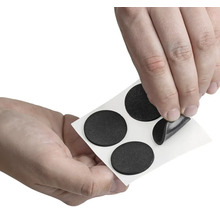 Osoba odstraňuje klzák nábytku z nosného papiera