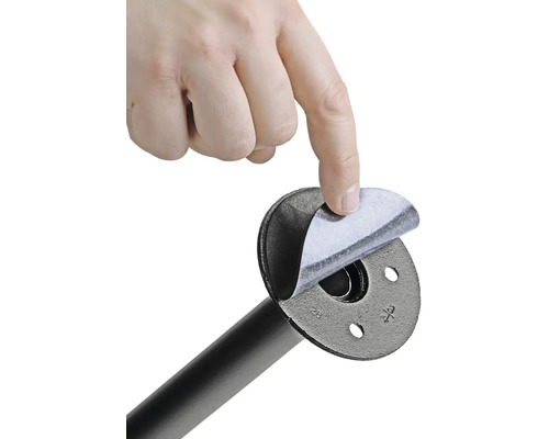 Ruka odstraňuje ochrannú fóliu z rúrkovej príruby.