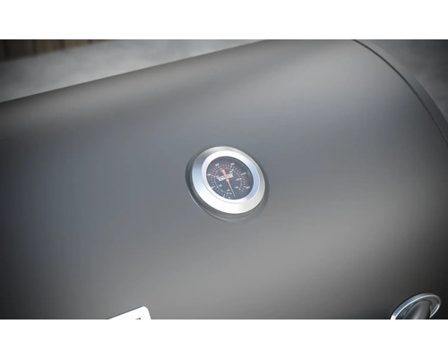 Detailný záber veka grilu s ukazovateľom teploty.