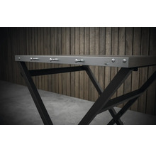 Detailný pohľad na skladací stôl s kovovým rámom a háčikmi