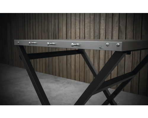 Detailný pohľad na skladací stôl s kovovým rámom a háčikmi