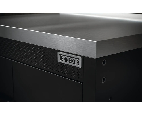 Detailný pohľad na pracovný stôl s nerezovou pracovnou doskou a logom Tenneker