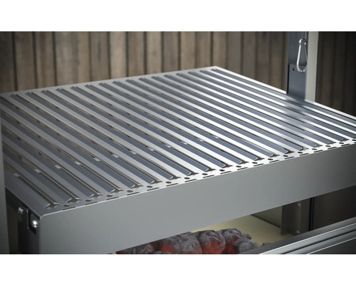 Kovový grilovací rošt nad dreveným uhlím