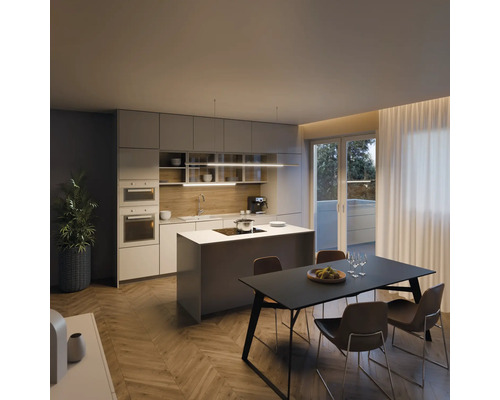 Moderná kuchyňa s kuchynským ostrovom, jedálenským stolom a stoličkami v svetlej miestnosti.