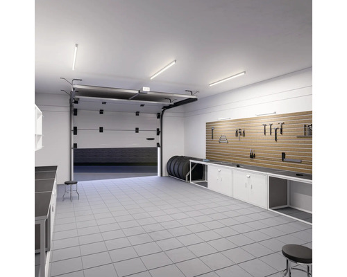 Garáž s pracovným stolom, stenou na náradie, pneumatikami a otvorenou garážovou bránou