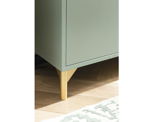 Detailný záber skrine so zlatými nohami na drevenej podlahe