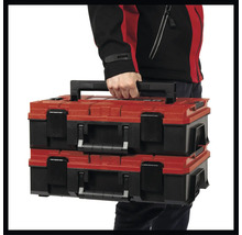 Dva červené a čierne kufríky na náradie, ktoré nesie jedna osoba.