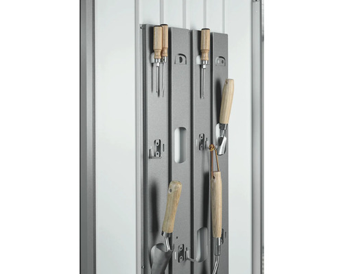 Záhradné náradie na sivom kovovom držiaku na uskladnenie.