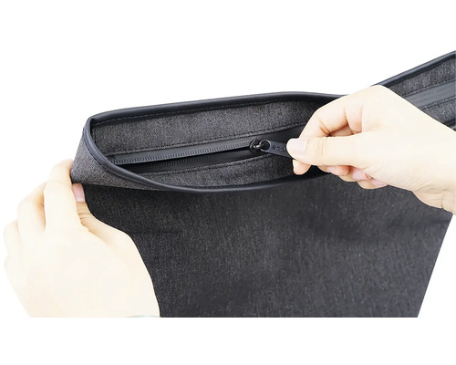 Detail šedej tašky so zipsom ovládaným rukami