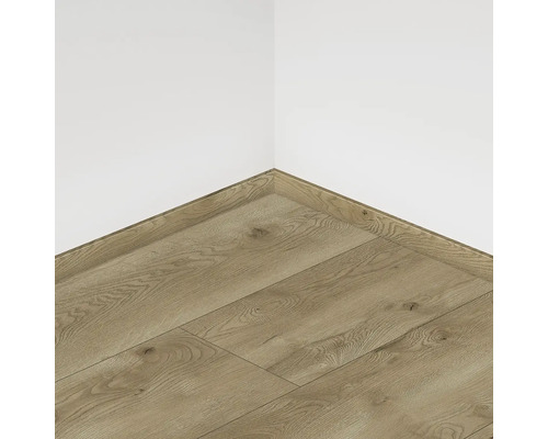 Položená laminátová podlaha so soklovou lištou pri bielej stene