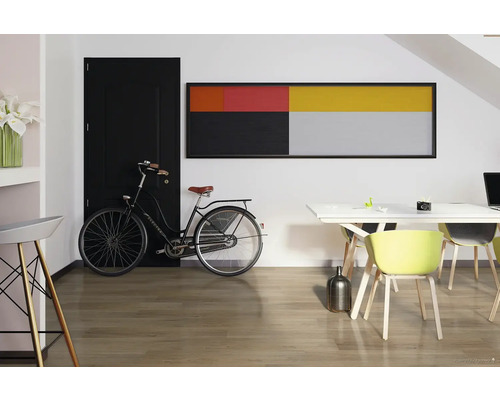 Moderná izba s čiernymi dverami, bicyklom, umeleckým dielom a jedálenským stolom na drevenej podlahe