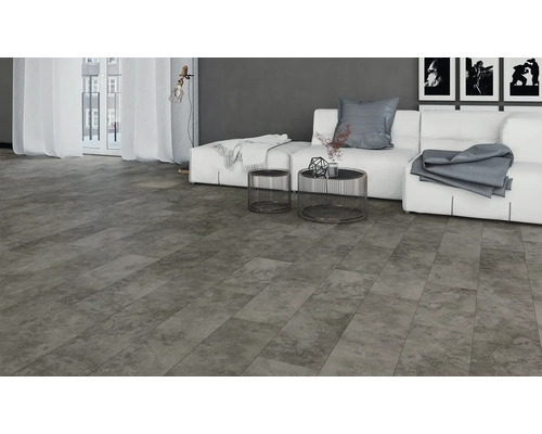 Obývacia izba so sivou dlažbou s kamenným vzhľadom, gaučom, stolom a oknom pre svetlé, moderné prostredie.