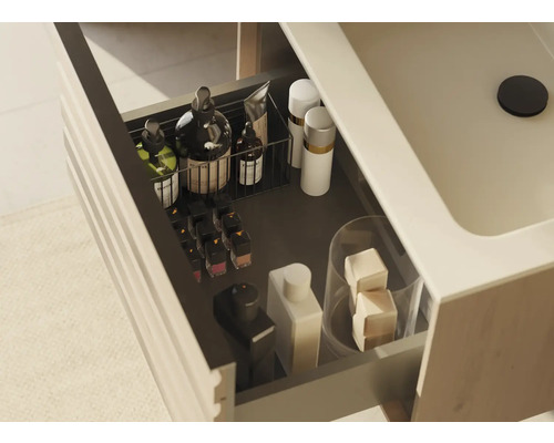 Otvorená zásuvka skrinky pod umývadlo s rôznymi kúpeľňovými potrebami na uloženie