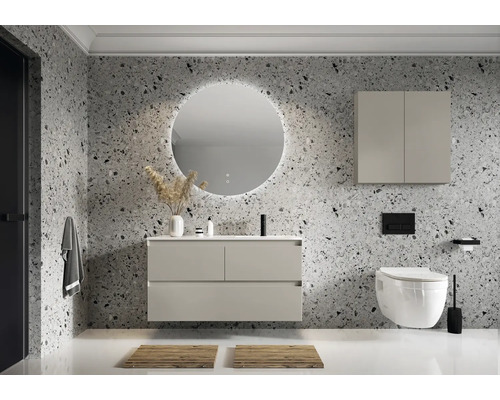 Moderná kúpeľňa s umývadlom, osvetleným zrkadlom, závesnou skrinkou a WC pred stenou s kamenným vzorom