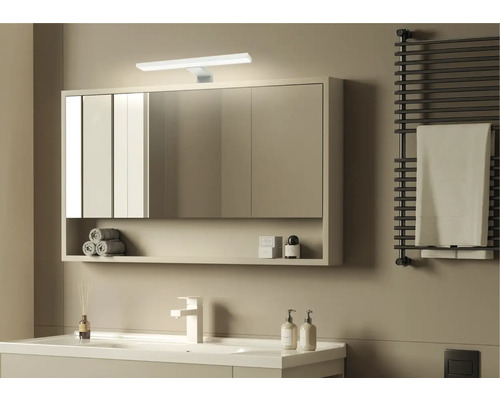 Moderná kúpeľňa so zrkadlovou skrinkou, umývadlom, radiátorom na uteráky a minimalistickým dizajnom