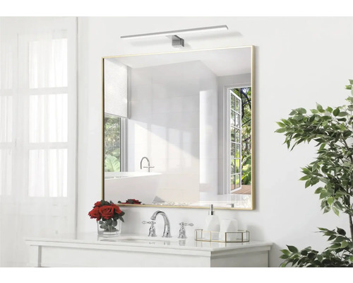 Štvorcové zrkadlo s osvetlením nad umývadlom v kúpeľni.