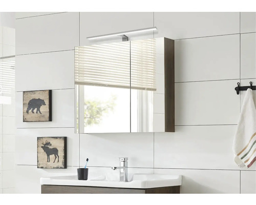 Moderná kúpeľňa so zrkadlovou skrinkou, umývadlom a dekoráciou na stenu