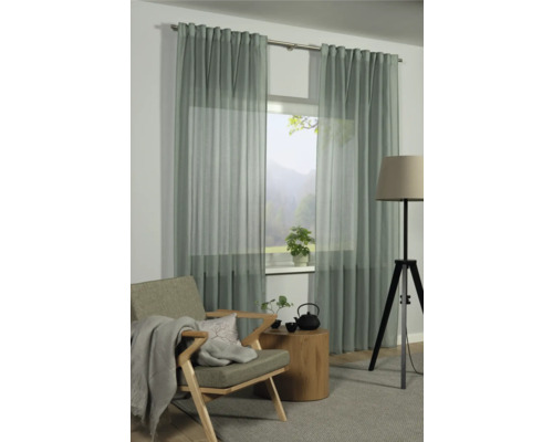 Obývacia izba s oknom a závesmi, kreslo, príručný stolík a stojacia lampa