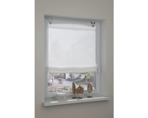 Okno s bielou skladanou roletou a dekoráciou na okennom parapete