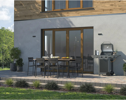 Terasa s grilom, jedálenským stolom a stoličkami pred domom