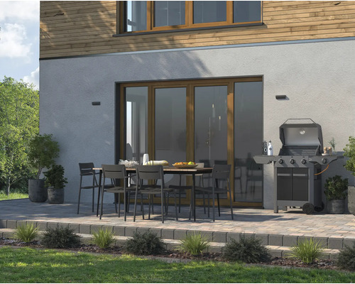 Terasa so záhradným stolom, stoličkami a grilom pred domom.