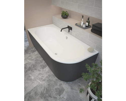 Voľne stojaca vaňa v kúpeľni s obkladanou stenou a rastlinou