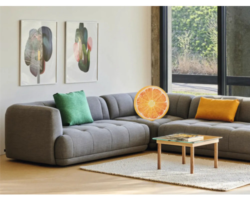 Obývacia izba so sivou rohovou sedačkou, vankúšmi a konferenčným stolíkom